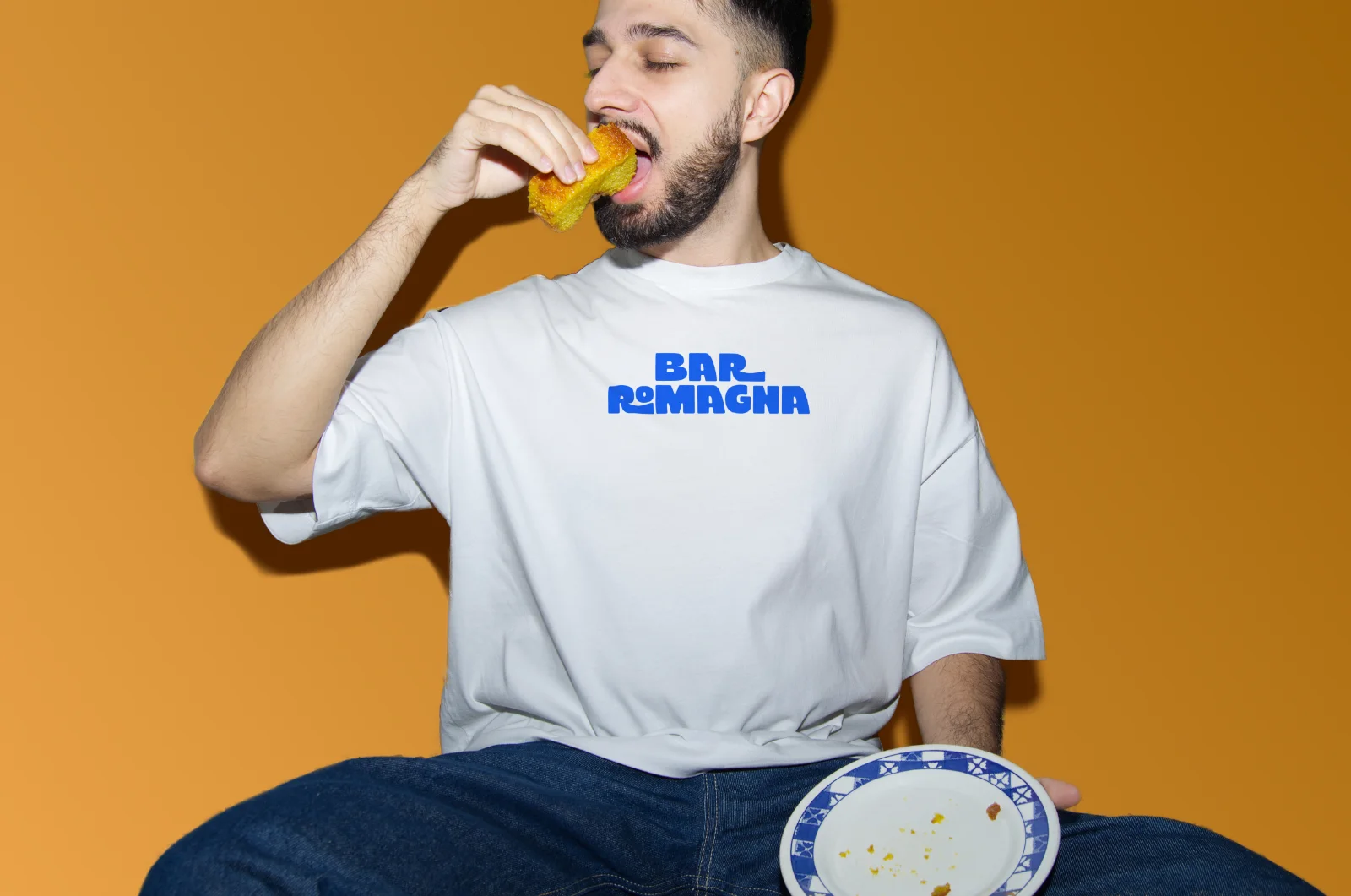 Persona con camiseta de Bar Romagna comiendo